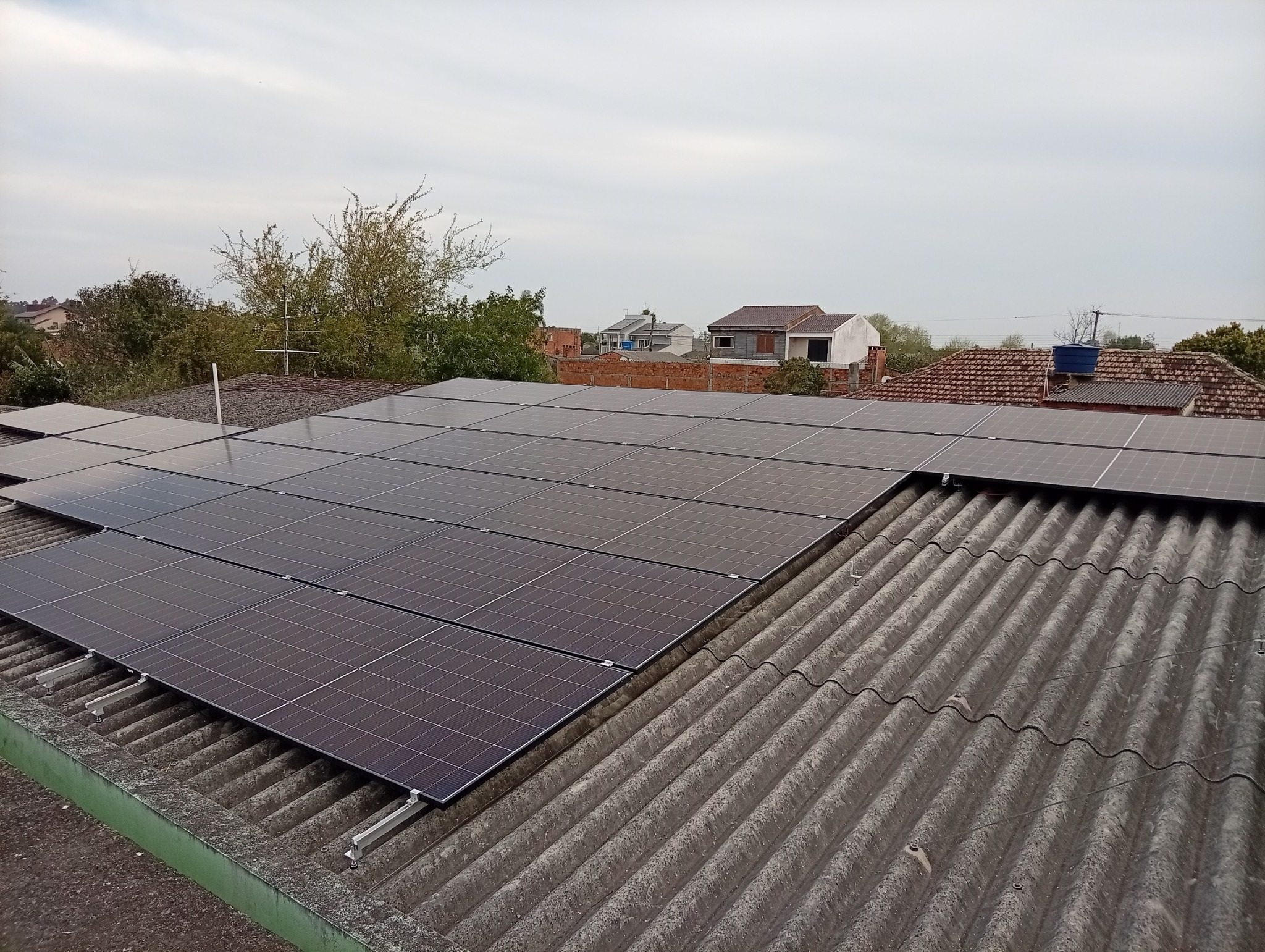 Sistema fotovoltaico residencial com 22 módulos de 620 W no Sítio Floresta — visão ampla do telhado